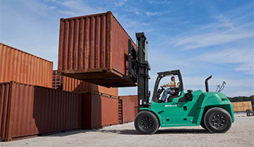 Operator Lifting Shipping Containers Outdoors with a Mitsubishi Diesel Pneumatic Tire Forklift